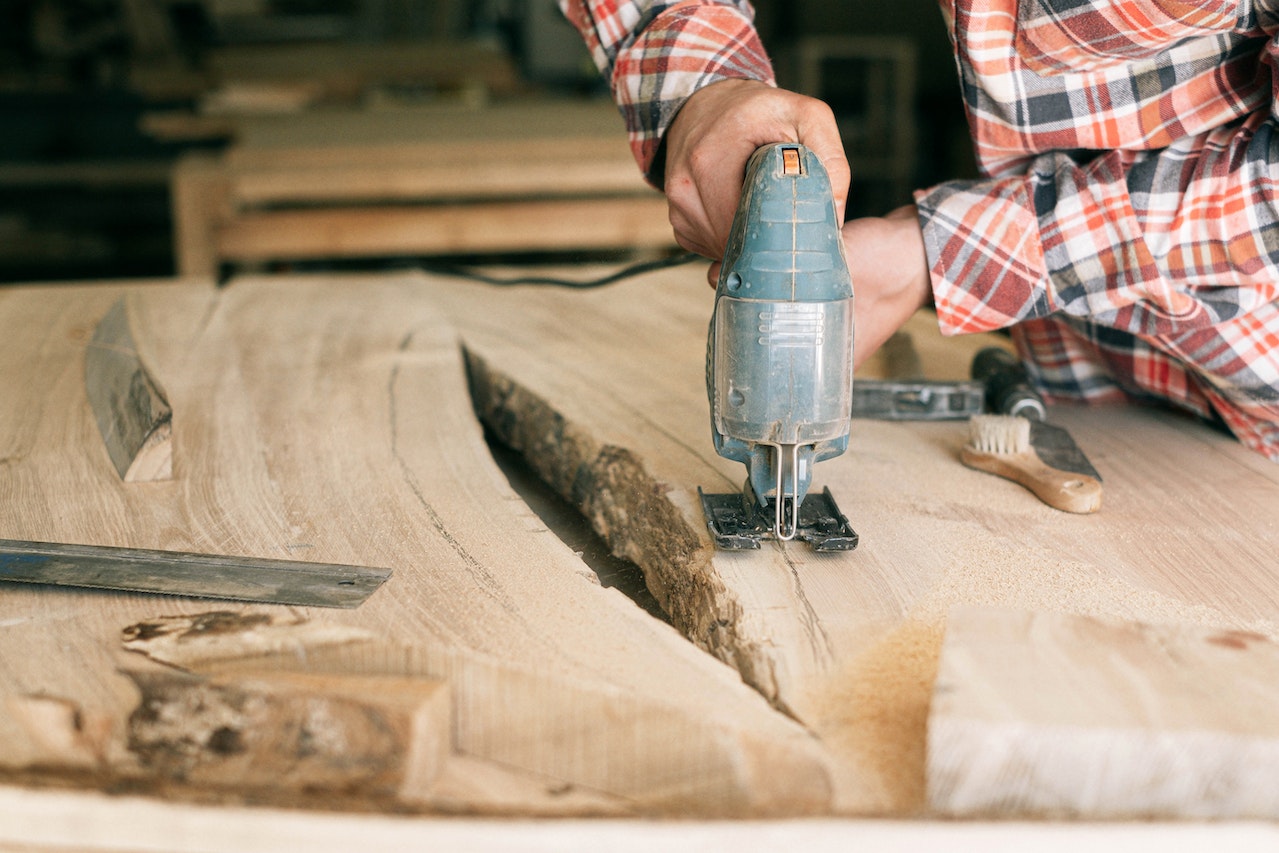 Person Cutting a Slab of Solid Wood