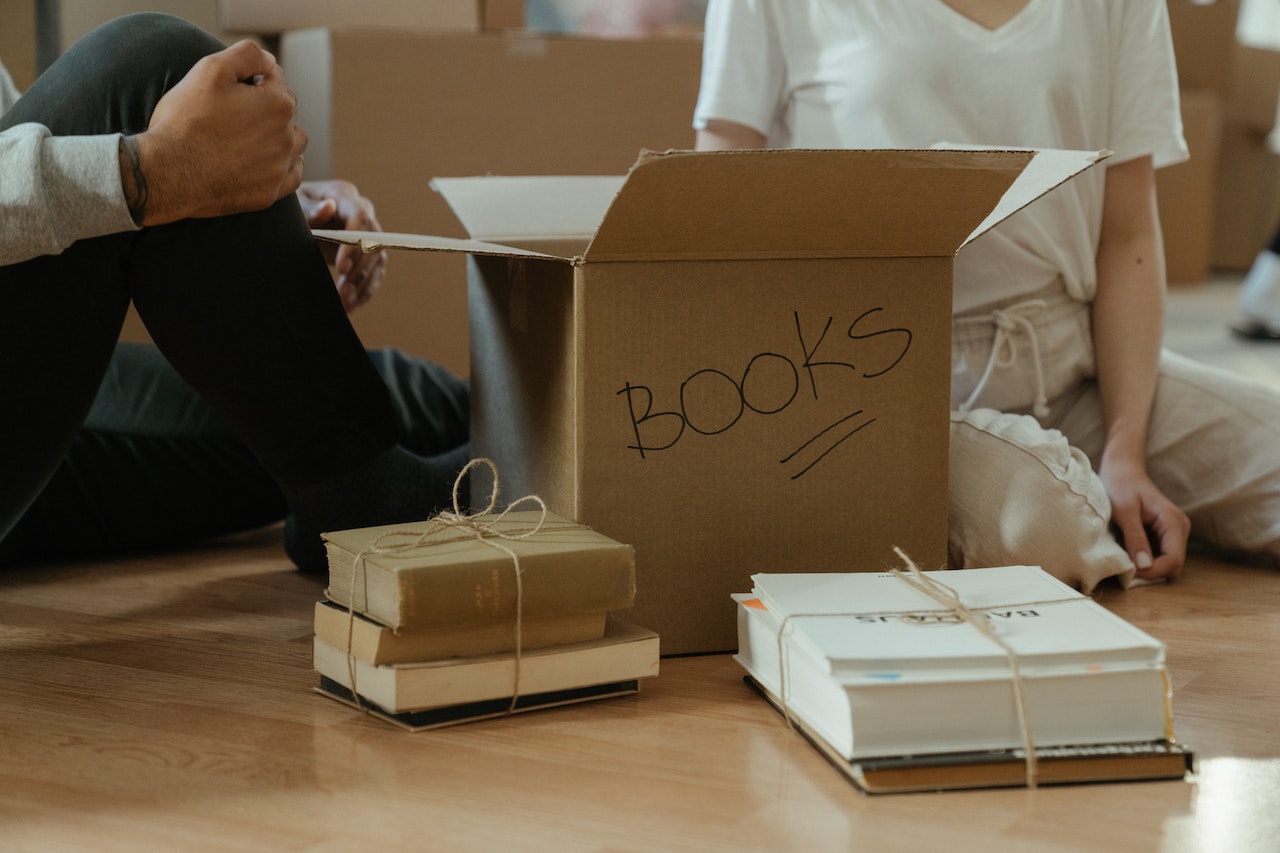 A pile of books organized with a box and tied with jute strings