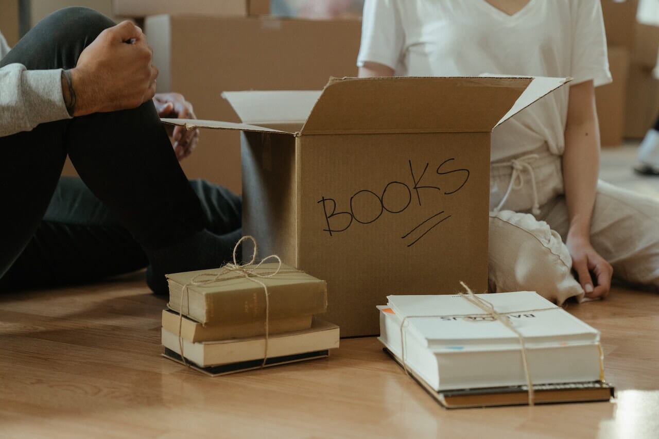 A pile of books organized with a box and tied with jute strings