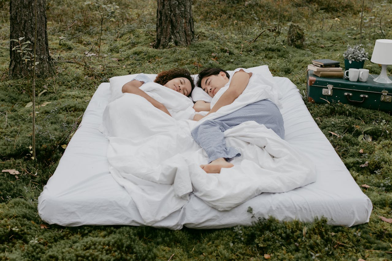 Couple sleeping on a mattress in the woods