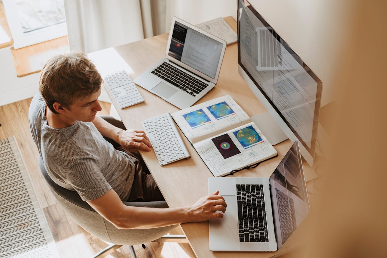 Man Using 3 Computers on Desk