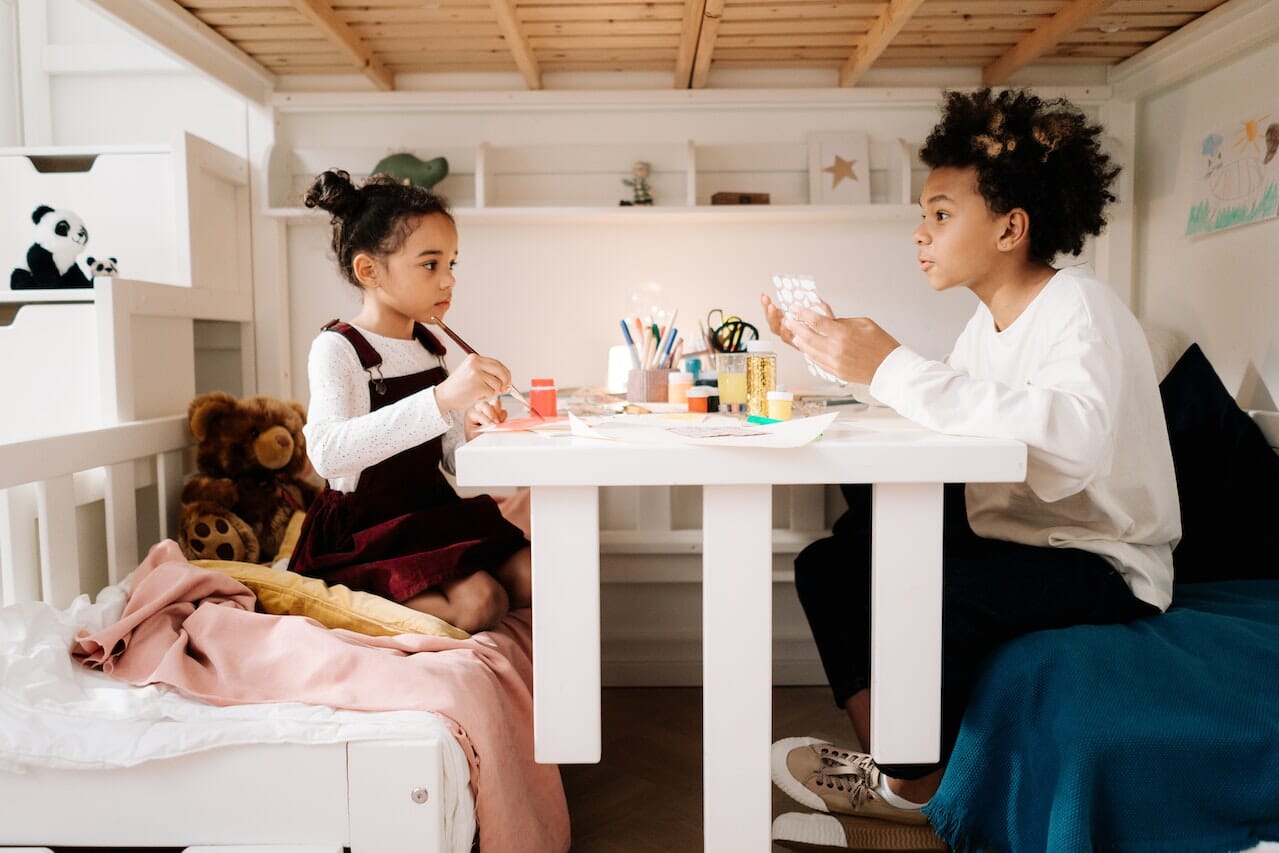 Siblings Doing Artwork Under Loft Bed