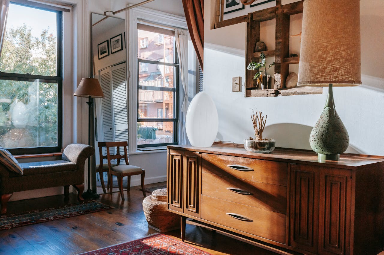 Warm and welcoming living room featuring vintage wood dresser and natural sunlight.