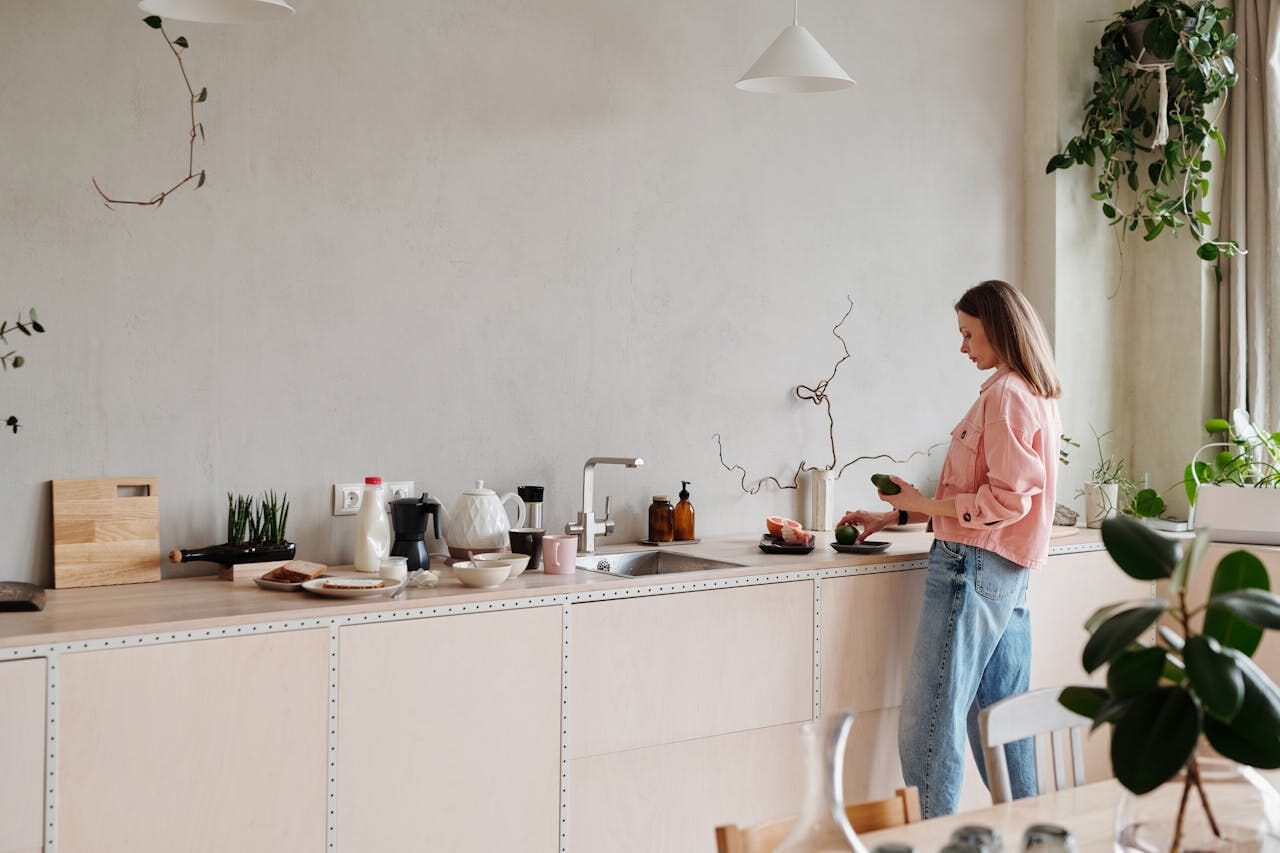 Woman in Pink Long Sleeve Shirt Holding Green Fruit - Maple Wood Cabinets