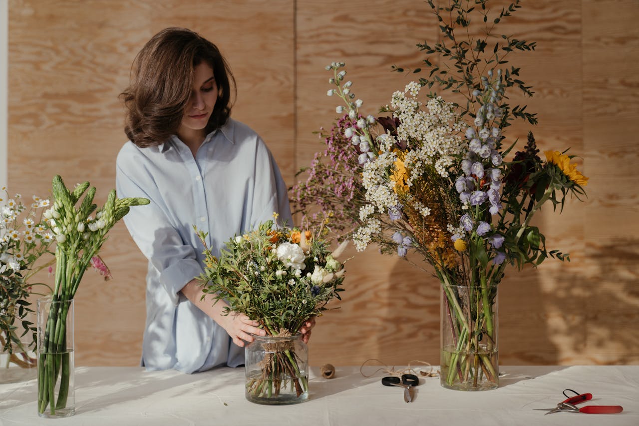 Woman in White Dress Shirt Holding Bouquet of Flowers
