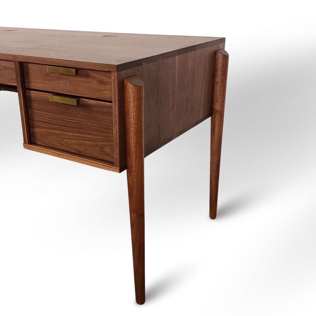 A close-up of the Apollo Solid Wood Executive Desk by TY Fine Furniture, handcrafted in Columbus, Ohio, featuring tapered legs, two drawers with brass handles, and a smooth finish—ideal for a stylish home office.