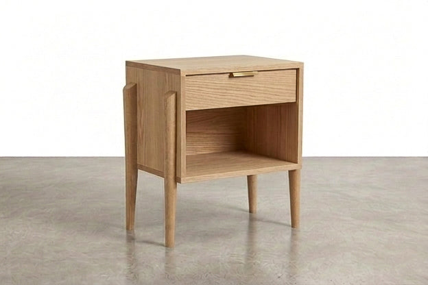 Crafted in solid hardwood, the Apollo Cube Side Table in White Oak by TY Fine Furniture showcases a Mid-Century Modern design with four tapered legs, a single drawer featuring a brass handle, and an open lower shelf. Photographed against a plain white background, this Columbus OH-made piece combines timeless style with functional elegance.