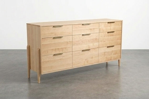 The Solid Maple 9-Drawer Triple Bank Dresser from the Apollo Collection by TY Fine Furniture, crafted from solid maple and featuring nine drawers with minimalist metal handles, stands on angled legs in a room with a plain gray floor.