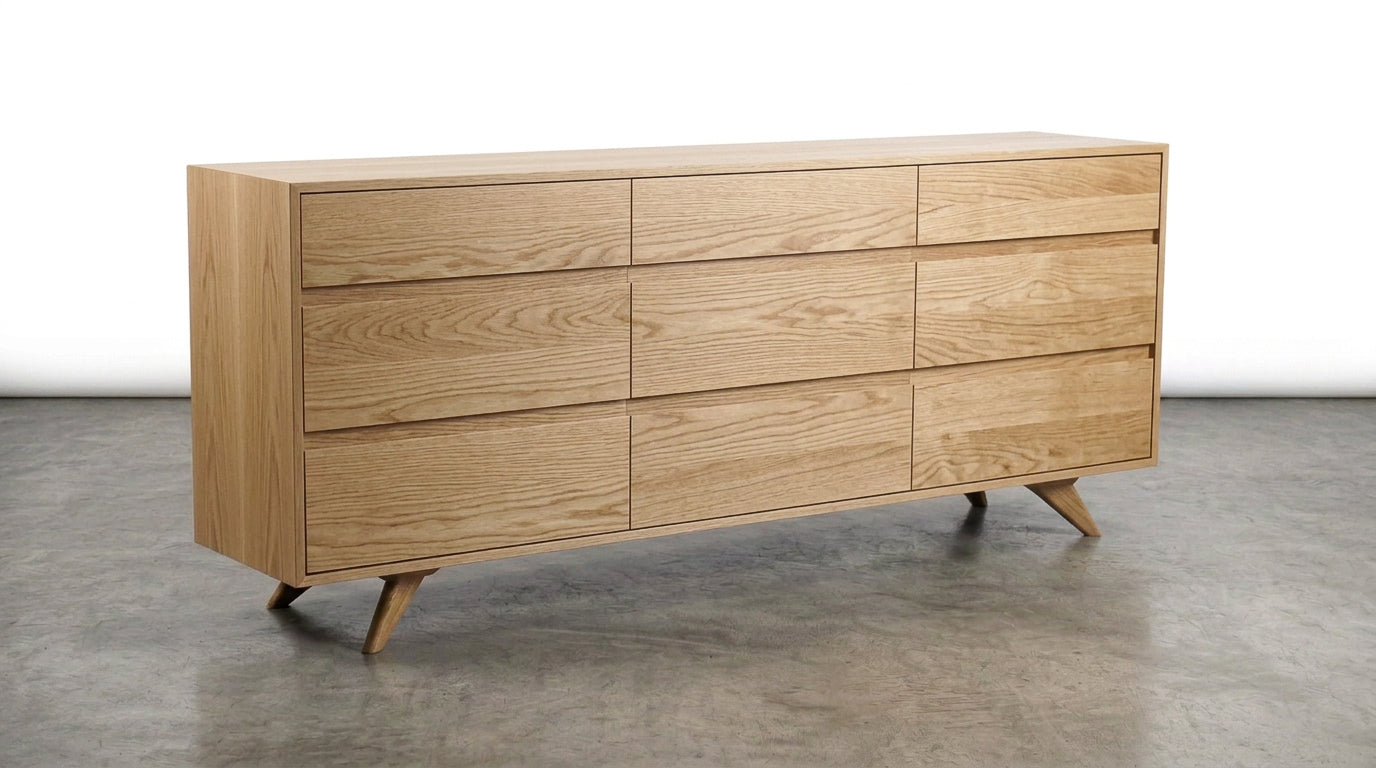 A modern solid white oak 6-drawer triple bank dresser from TY Fine Furniture’s Modern Collection, featuring angled legs and a light natural finish, sits on a polished concrete floor against a plain white background.
