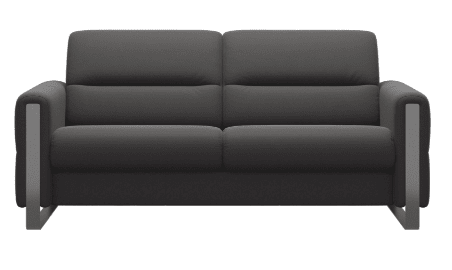 The Stressless Fiona (available as a 3 seater, 2.5 seater, 2 seater, or 1 seater) by Stressless is a modern dark gray sofa with thick cushions and metal armrests, shown from the front against a white background.