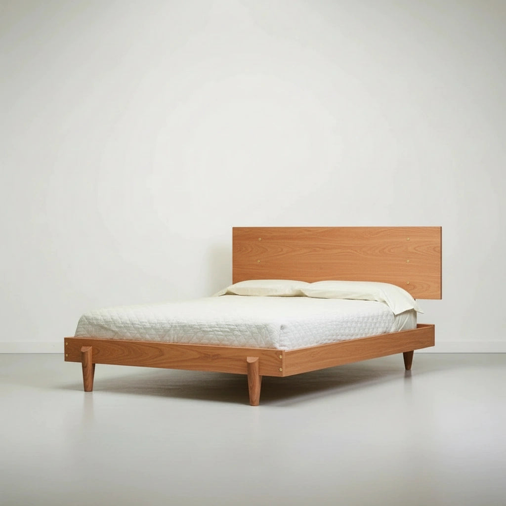 The Apollo Platform Bed by TY Fine Furniture, crafted from solid cherry wood, features a minimalist design with a simple headboard and light bedding in a modern, uncluttered room with white walls and floor.
