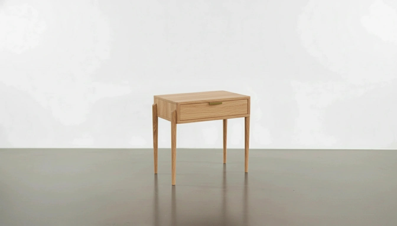 The Apollo Solid Wood Side Table by TY Fine Furniture, handcrafted in cherry wood in Columbus, Ohio, features four slender legs and a single drawer, and is shown on a smooth gray floor against a plain white background.