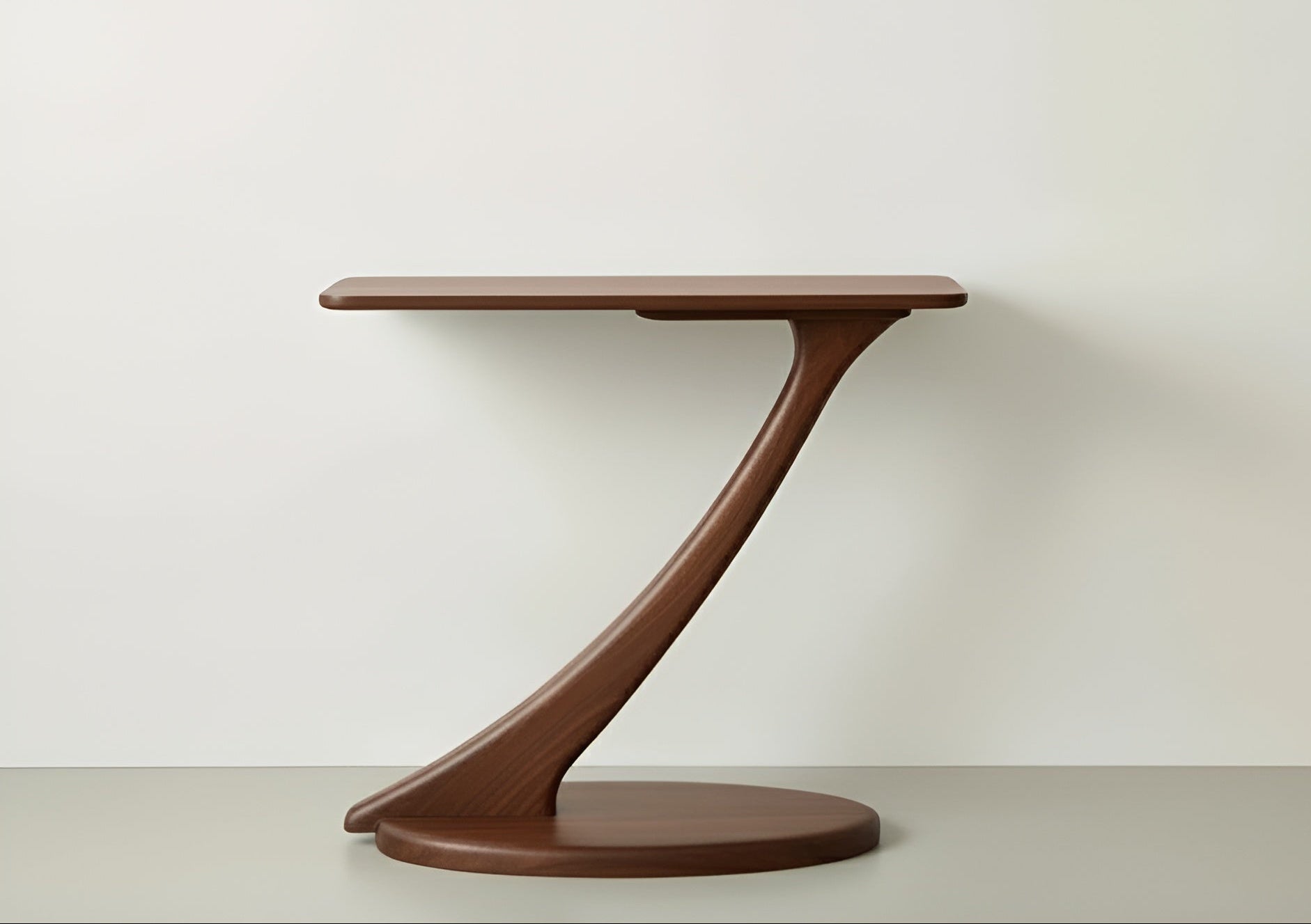 The Cantilever Console Hall Table by TY Fine Furniture features a modern, eco-friendly walnut design with a round base, single curved support, and rectangular tabletop, shown against a plain, light-colored background.