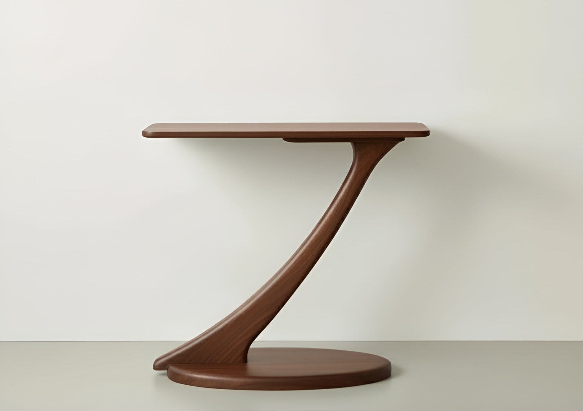 The Cantilever Console Hall Table by TY Fine Furniture features a modern, eco-friendly walnut design with a round base, single curved support, and rectangular tabletop, shown against a plain, light-colored background.