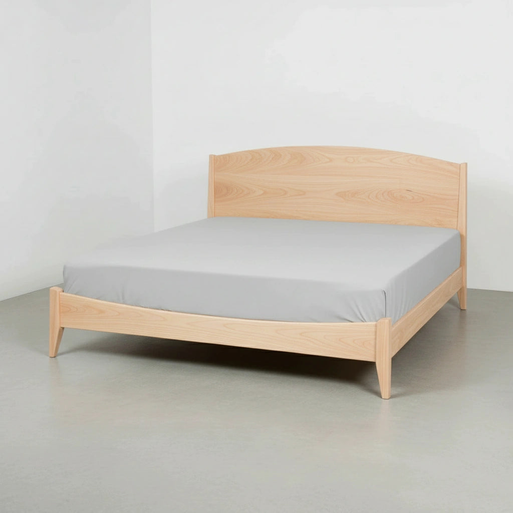 The T.Y. Fine Furniture Shaker Platform Bed - Solid Wood Bed Frame, in a light wood finish with a plain light gray mattress, stands in a minimalist empty room with white walls and a gray floor.