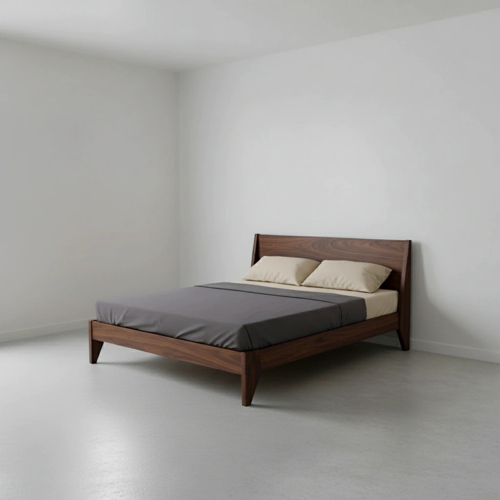 A minimalist bedroom with the Modern "TWO" Platform Bed by TY Fine Furniture, handmade from solid walnut with an organic finish, styled with gray bedding and beige pillows against white walls and a light floor.