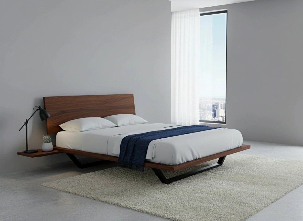 A modern minimalist bedroom showcases the Nelson Solid Wood Platform Bed Frame by TY Fine Furniture in premium walnut, styled with white bedding, a navy throw, built-in nightstand, black lamp, large window with white curtains, light rug, and gray floor.