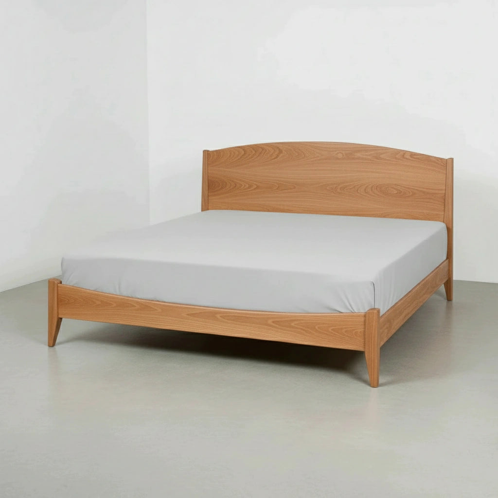 The T.Y. Fine Furniture Shaker Platform Bed - Solid Wood Bed Frame with a minimalist design and light wood finish supports a mattress with a plain light gray fitted sheet, placed in an empty room with pale walls and flooring.