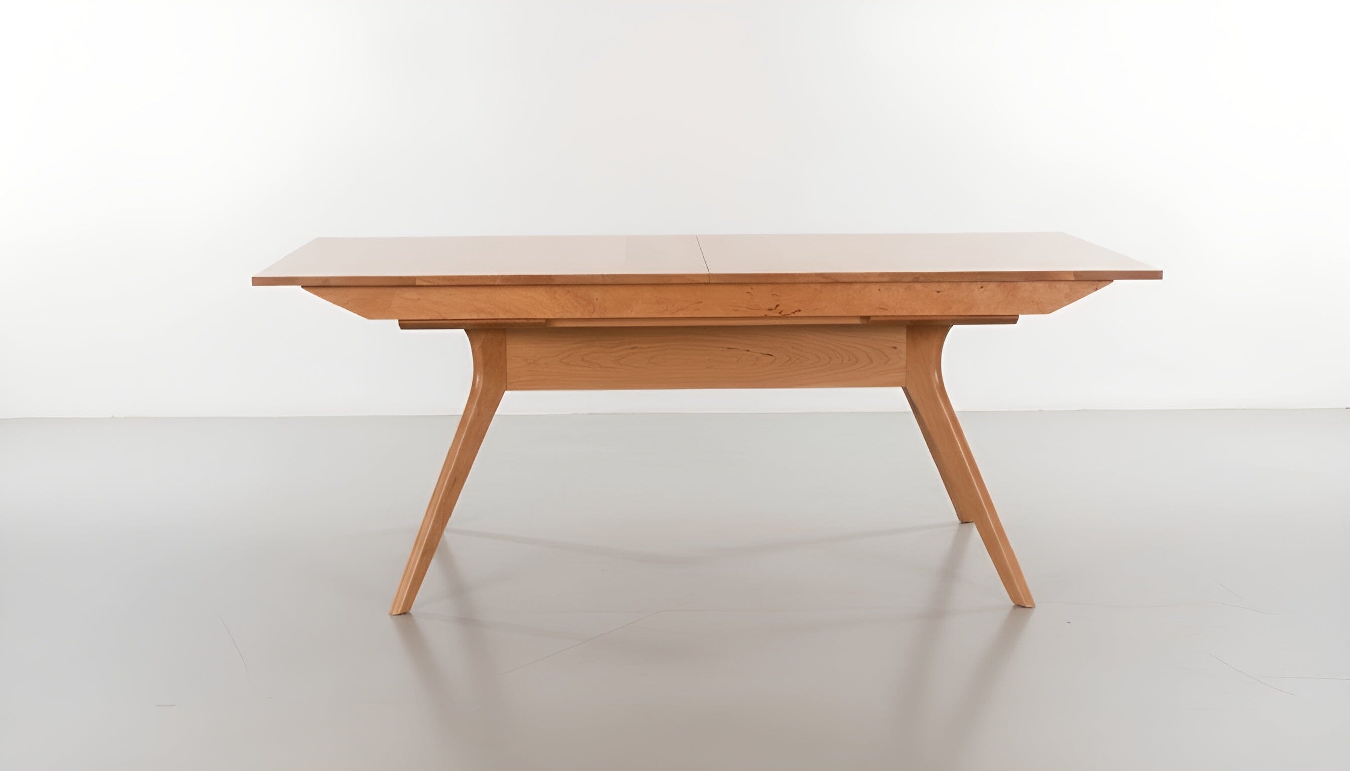 The Strata Extendable Dining Table by TY Fine Furniture features a solid cherry wood rectangular top and angled legs, displayed against a plain white background.