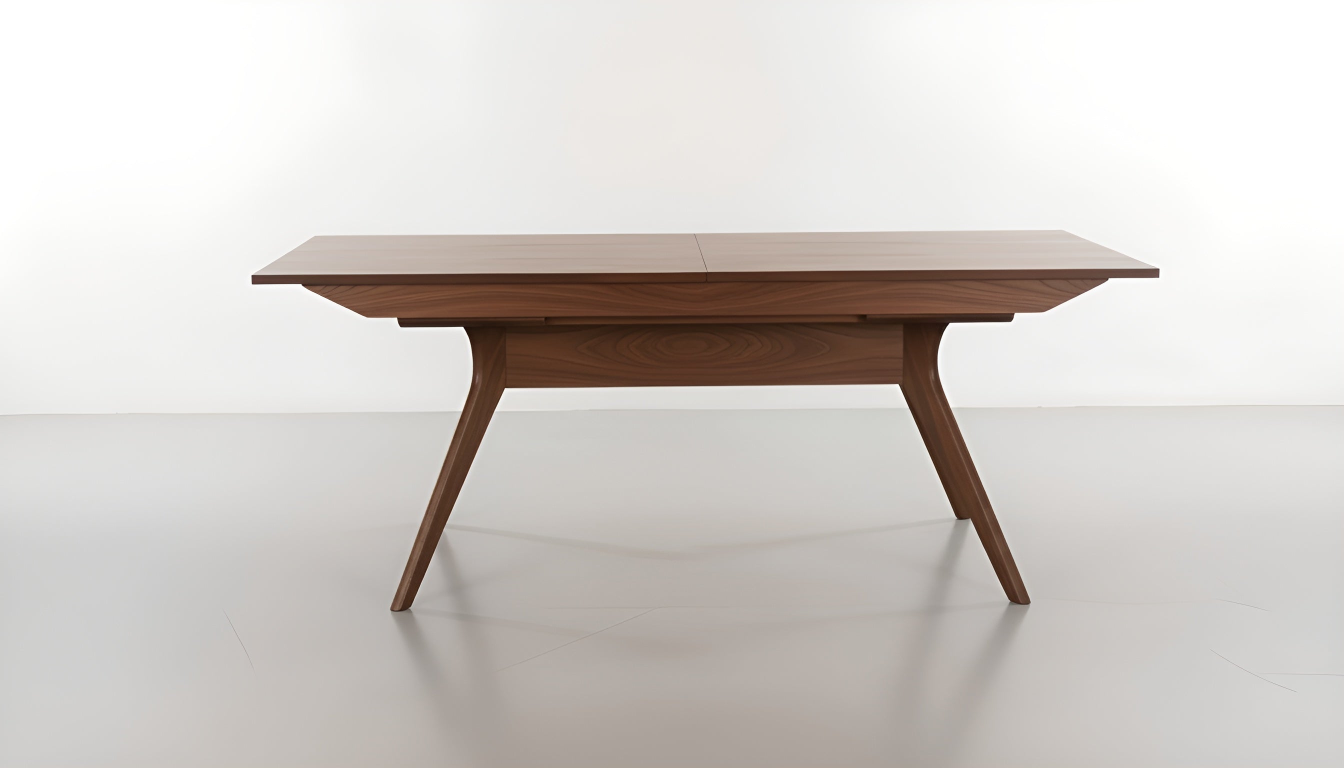 The Strata Extendable Dining Table by TY Fine Furniture features a smooth walnut rectangular top and angled solid wood legs, showcased against a plain white background.