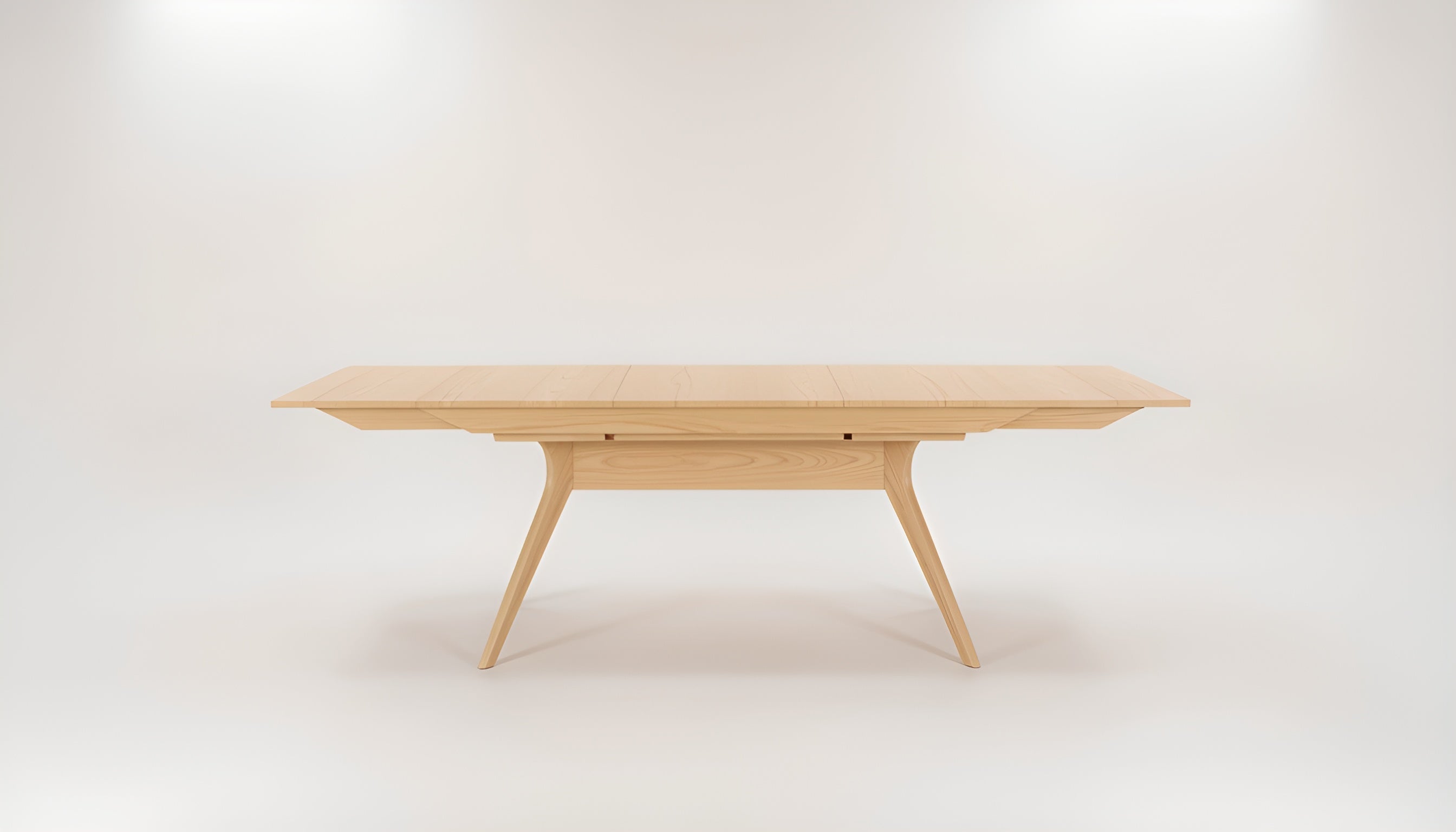 The Strata Extendable Dining Table by TY Fine Furniture features a modern rectangular solid white oak top with angled legs and a light finish, displayed against a plain white background.