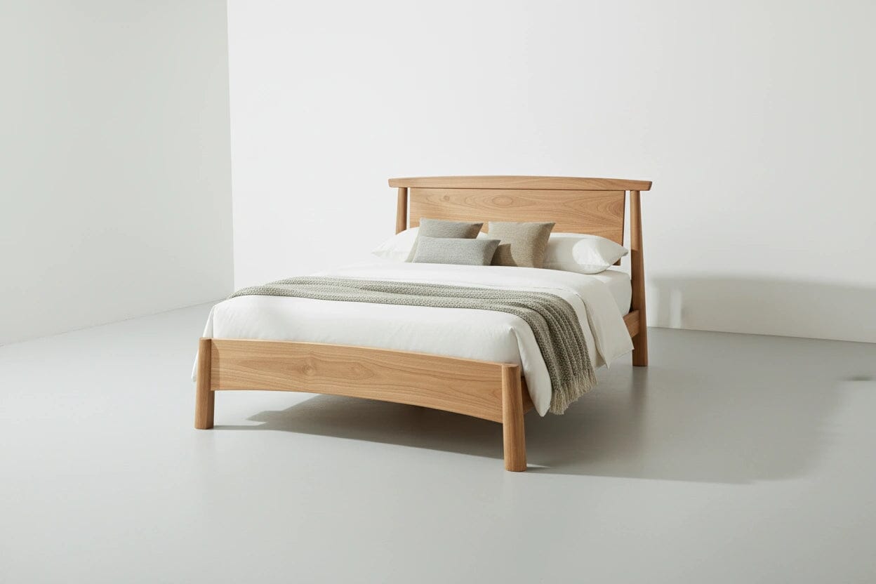 Wooden bed with white bedding and pillows on a plain background. This is the Sunrise Platform Bed, made by TY Fine Furniture in Ohio, USA, from natural hardwood white oak.