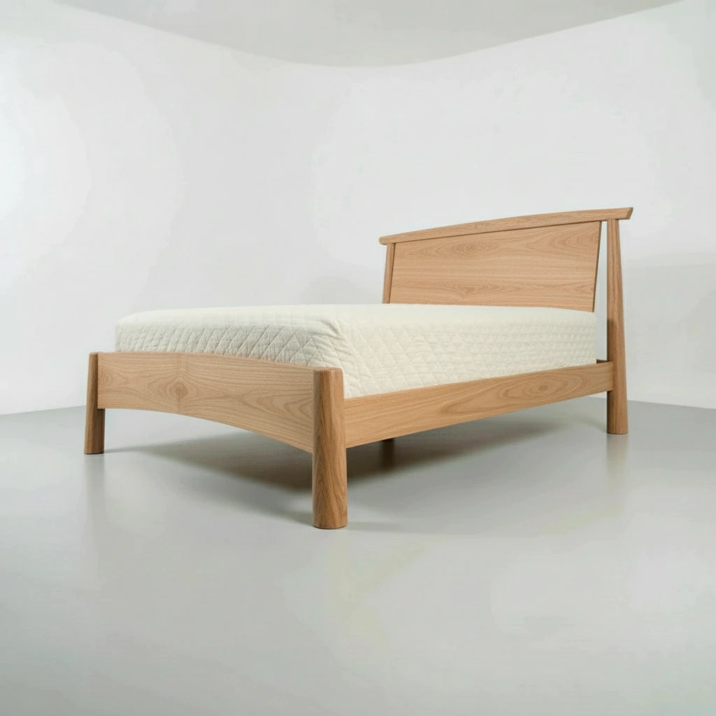 Wooden platform bed frame made of solid white oak with a white mattress on a plain background