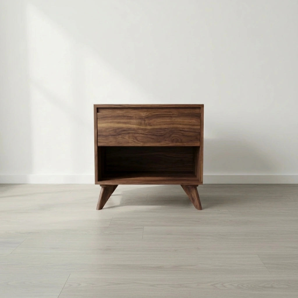 The Modern Cube Side Table - Walnut by TY Fine Furniture features solid wood construction, angled legs, a push-to-open drawer with Italian slides, and an open lower shelf, shown on a light wood floor against a plain white wall.