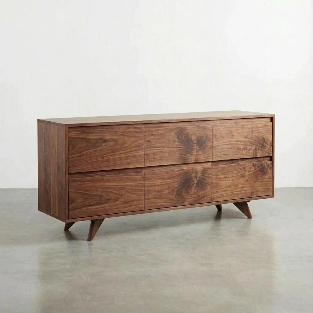The TY Fine Furniture Modern Dresser features a mid-century design with six drawers, angled legs, and solid walnut wood, blending timeless style and craftsmanship against a light wall and concrete floor.