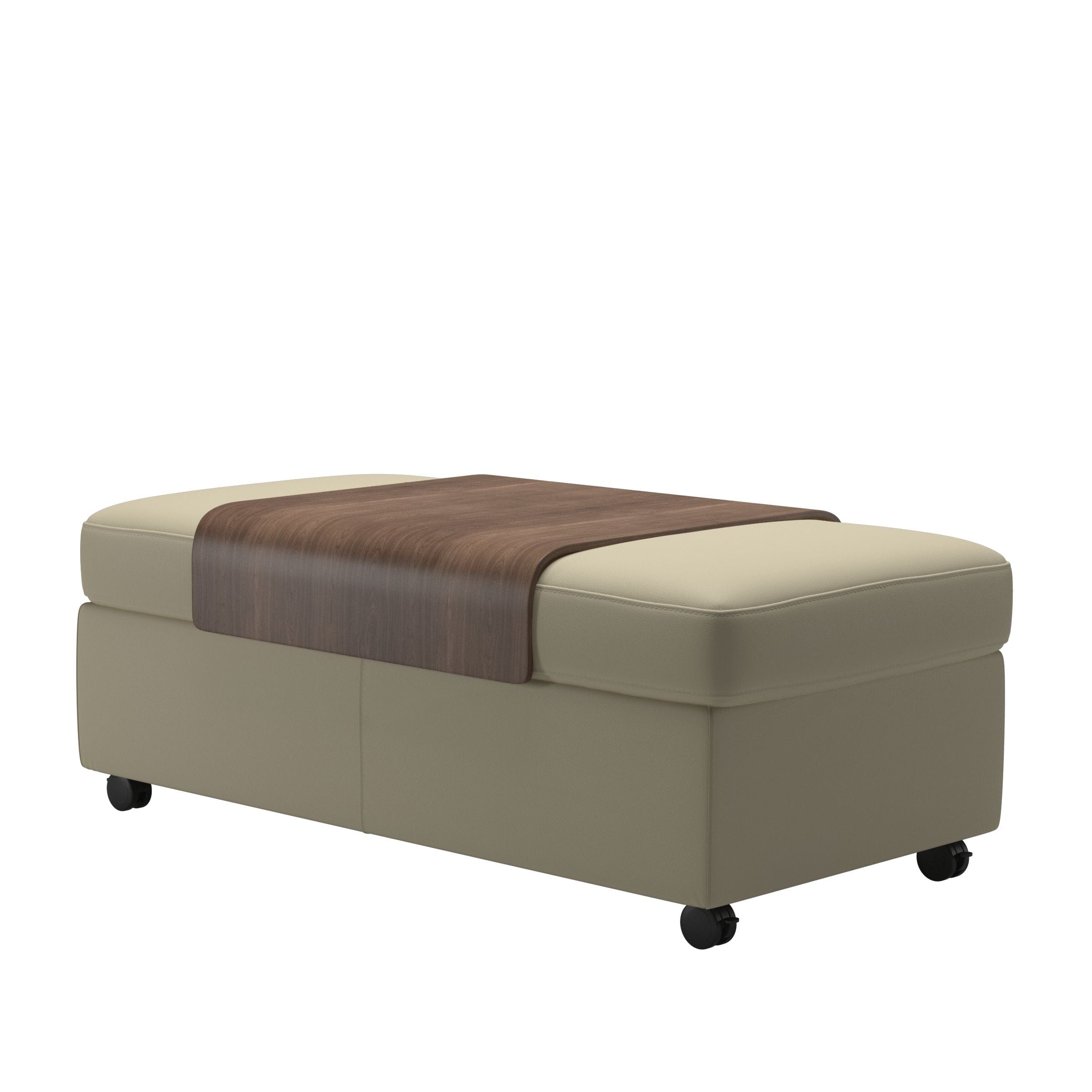 The Stressless Double Ottoman Coffee Table by Stressless features beige upholstery, hidden storage, wheels, and a rectangular wooden tray top—ideal as a versatile coffee table. Shown against a white background.