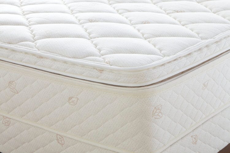 Close-up of a white, quilted mattress with a soft, padded top and leaf-stitched sides—enhanced by the TY Sleep Luxury Mattress Topper from TY Sleep (Columbus, OH) for improved sleep health.