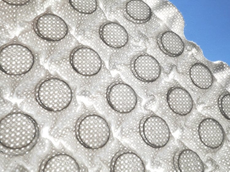 Close-up of bubble wrap with round air-filled bubbles against a blue background, evoking the plush, textured surface of the TY Sleep Luxury Mattress Topper by TY Sleep in Columbus, OH.