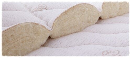 Close-up of the TY Sleep Luxury Mattress Topper’s cross-section, highlighting its layered, quilted structure with soft cream-colored padding and stitching—crafted by TY Sleep in Columbus, OH to enhance sleep health.