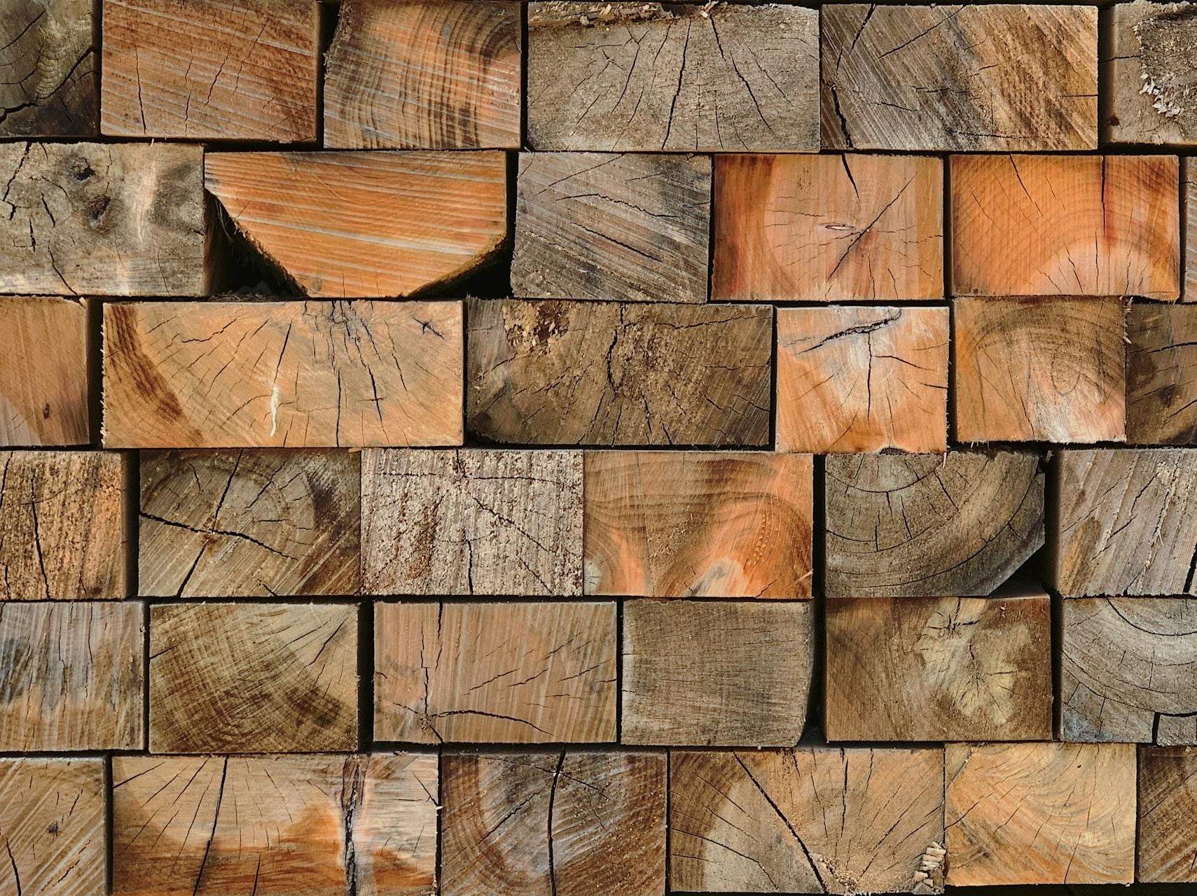 Close-up of vertically stacked solid wood lumber showcasing unique grain patterns and textures.