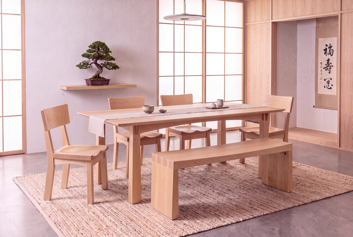 Minimalist dining room featuring the Solid Maple Dining Table - Enso Collection | TY Fine Furniture, paired with a bench and chairs on a woven rug. Shoji screens, a bonsai on a floating shelf, and a hanging scroll complete the serene space.