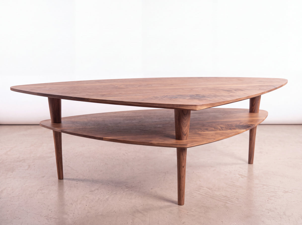 Solid Walnut Coffee Table - Atomic Collection by TY Fine Furniture, featuring a handmade triangular top, matching lower shelf, and three tapered legs.