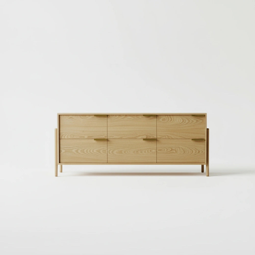 A wooden dresser with six drawers and gold handles from the front.