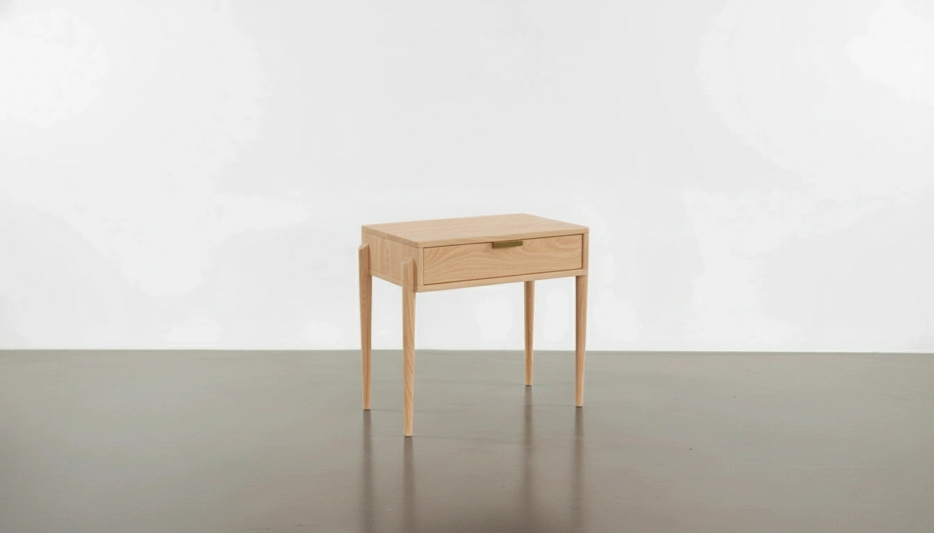 The Apollo Solid Wood Side Table by TY Fine Furniture, handcrafted in Columbus, Ohio, features light wood, four slender legs, and a single drawer—adding classic Mid-Century Modern style against a simple white backdrop.