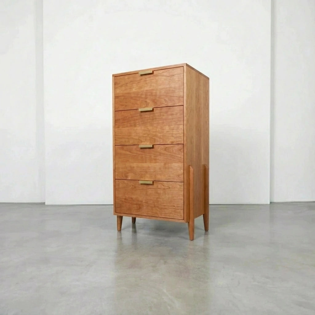 The TY Fine Furniture Apollo Tall Dresser in cherry is a solid wood piece with four drawers, minimalist gold handles, soft-close slides, and tapered legs—perfect for a modern space with a polished concrete floor.