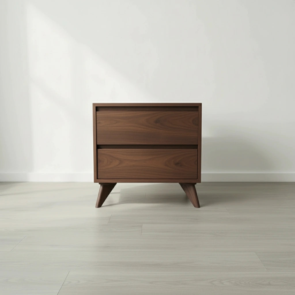The TY Fine Furniture Modern Cube Side Table - Walnut, made of solid wood with two push-to-open drawers and angled legs, is placed on a light hardwood floor against a plain white wall.