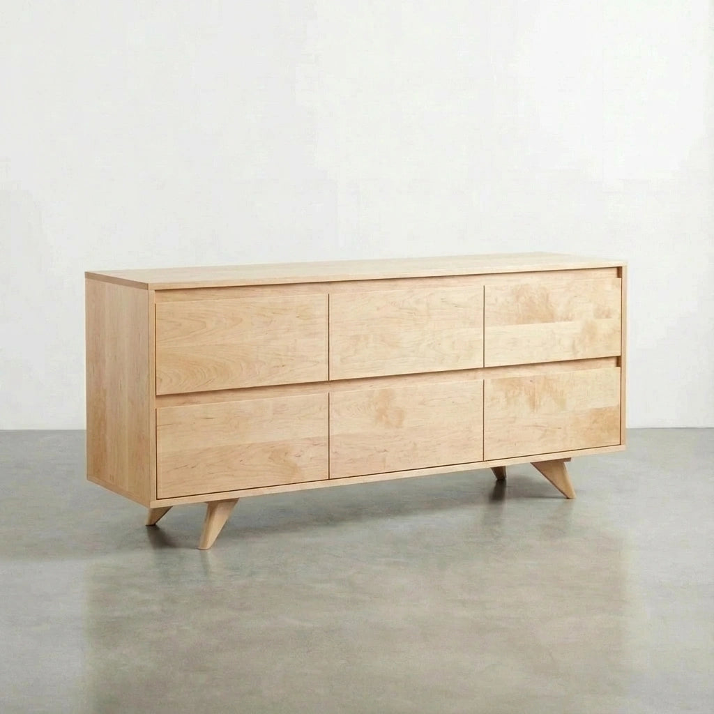 The TY Fine Furniture Modern Dresser is a mid-century modern maple dresser featuring six solid wood drawers and angled legs, shown against a plain white wall on a polished concrete floor.