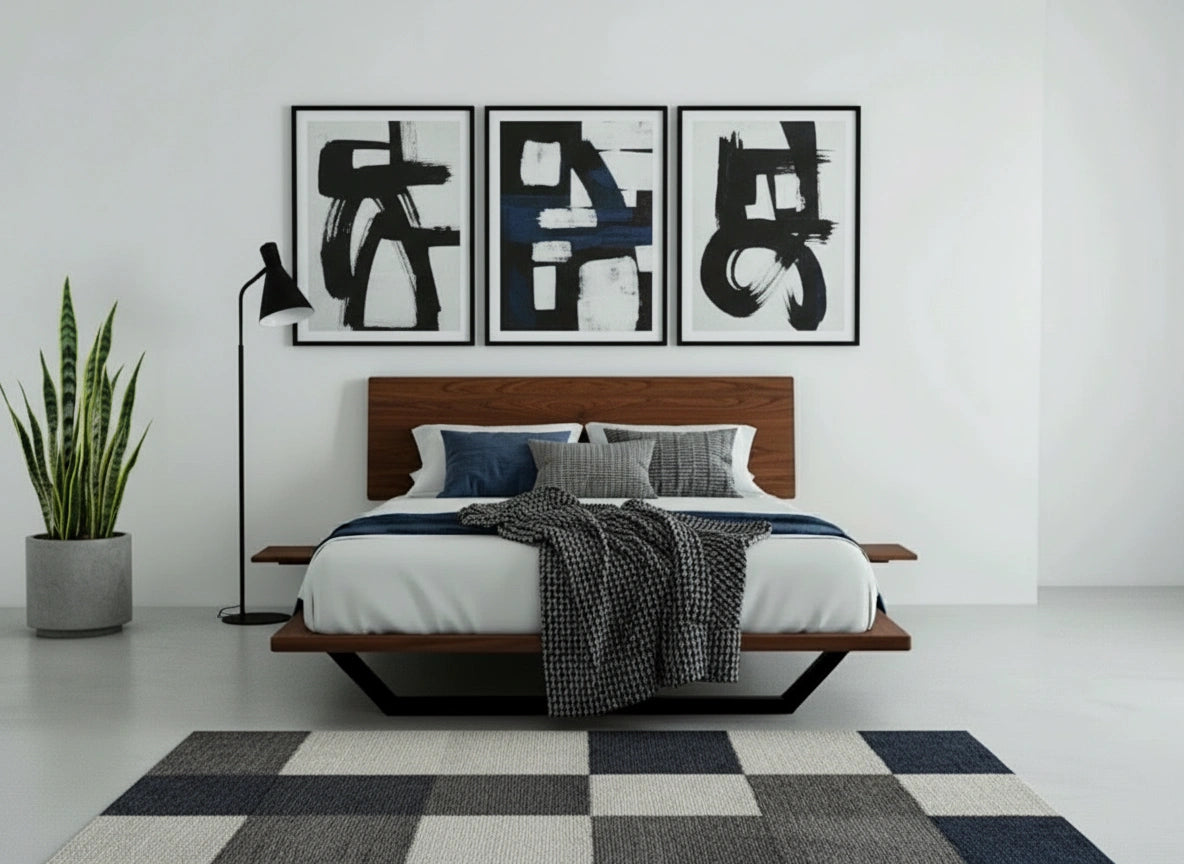 A modern bedroom featuring the TY Fine Furniture Nelson Solid Wood Platform Bed Frame in premium walnut, blue and gray bedding, three abstract black-and-white artworks over the headboard, a tall potted plant, black floor lamp, and checkered rug on a light floor.