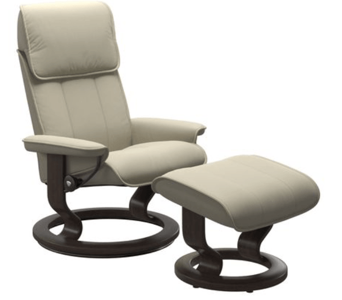 A beige leather reclining chair and ottoman with a wooden base from another angle
